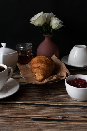 Breakfast with coffee, croissant and jam on wooden tableの写真素材