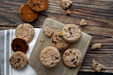 Chocolate chip cookies with raisins on a wooden cutting board