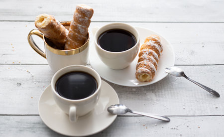Two cups of coffee and croissants on a white wooden tableの写真素材