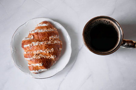 Breakfast with coffee and croissant on a white background.