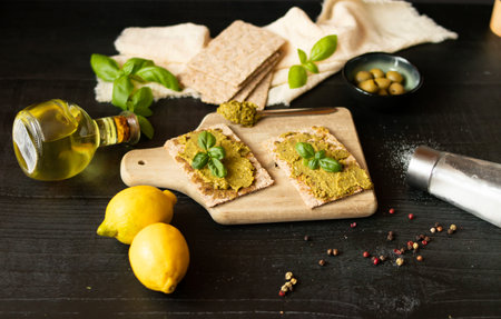 Healthy snacks: crackers with hummus, olive oil and basilの写真素材