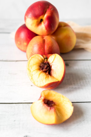 Ripe peaches on a white wooden background. Organic fruit.