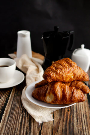 Croissants and coffee on a wooden background. French breakfast.の写真素材