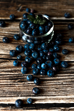 Blueberries in a glass bowl on a wooden background. Selective focus.の写真素材