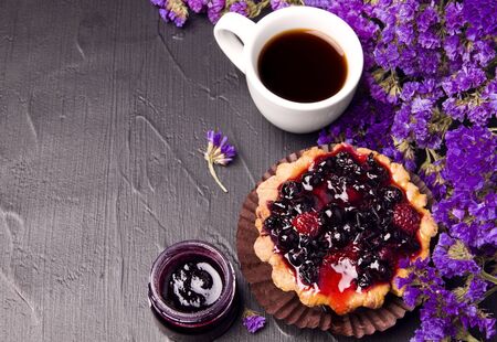 coffee, cake and flowers on a black background. Breakfast. Copy spaceの写真素材
