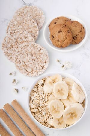 healthy breakfast of oatmeal with banana and oatmeal cookies on a white background.の写真素材