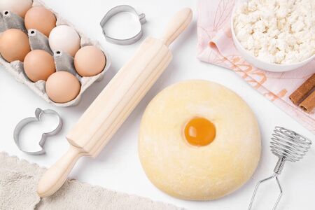 raw dough ready for baking on a white plate next to the ingredients. Homemade food conceptの写真素材