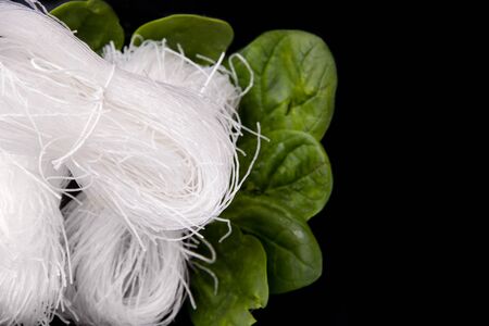 Noodles in a black plate with herbs. raw funcheza.copy spaceの写真素材