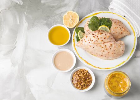 chicken fillet next to sauces on a concrete gray background with copy spaceの写真素材