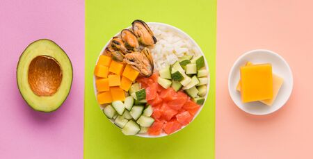 diced poke salad next to avocado and cheese on a green, yellow and purple backgroundの写真素材