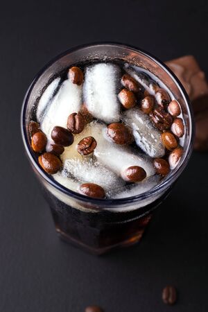 coffee soda with ice on a black background in a glass. vertical imageの写真素材