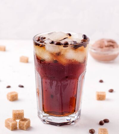 iced coffee on a white background. next to cane sugar.の写真素材