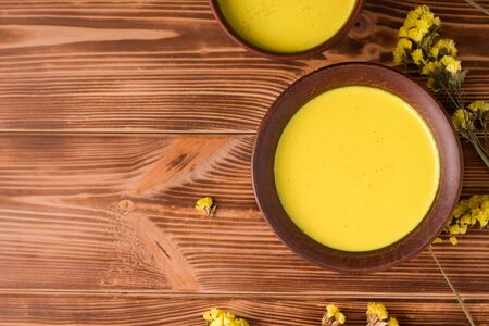 traditional indian drink golden milk in a rustic concept. on wooden background with copy spaceの写真素材