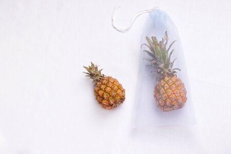 grocery eco bag of blue color with tropical fruit pineapple on a white background. copy spaceの写真素材