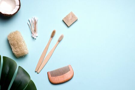 eco bath accessories such as a toothbrush, comb and ear sticks made of wood and a loofah washcloth. blue background. copy space.の写真素材