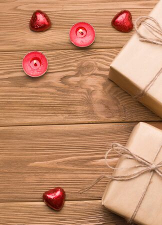 gifts on a wooden table. Close to sweets and candles. There is a text. Valentine's day celebration concept. vertical imageの写真素材