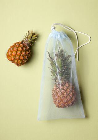 pineapple in an eco bag on a green background.の写真素材