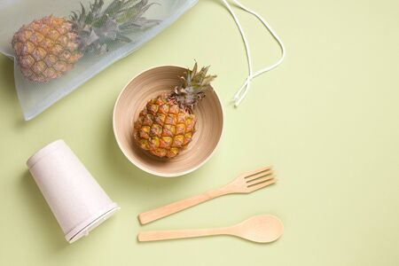 eco kitchen utensils made of bamboo, wood and metal straw. on a green background. copy spaceの写真素材
