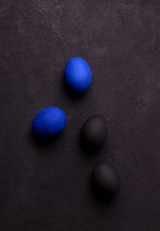 blue and black easter eggs on a black background in the style of minimalism. horizontal imageの写真素材
