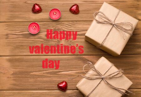 gifts on a wooden table. Close to coffee and candles. There is a text. Valentine's day holiday conceptの写真素材