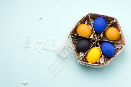 painted easter eggs on a blue background in a wooden box