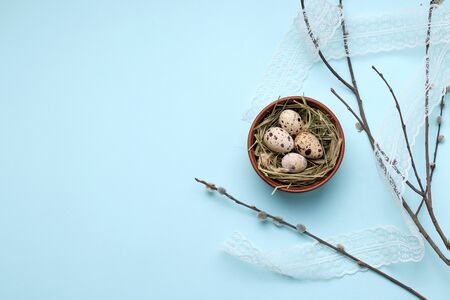 quail Easter eggs in a clay bowl next to willow branches. have copy spaceの写真素材