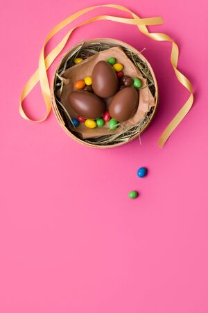 chocolate easter eggs on a pink background. vertical photo copy spaceの写真素材