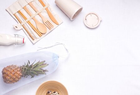 cutlery made of bamboo next to an eco bag on a linen background with copy space. zero waste concept...