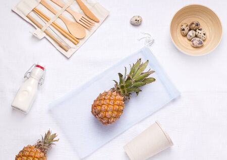 on white linen fabric are wooden cutlery, a glass and a bowl of bamboo, an eco bag and a glass bottle with milkの写真素材