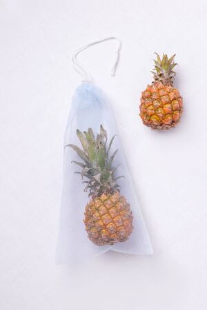 on a white linen cloth is a blue eco bag with pineapple. natural concept zero wasteの写真素材