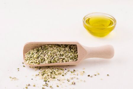 peeled hemp seeds in a wooden scoop on a white background. copy spaceの写真素材