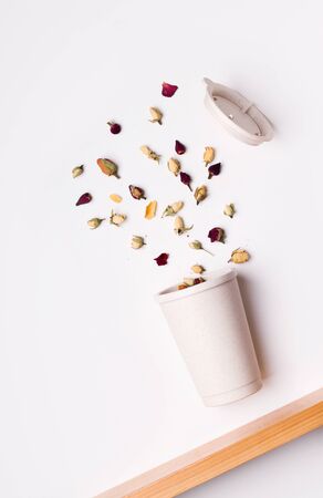 reusable cup with tea in flight on a wooden table. white background.の写真素材