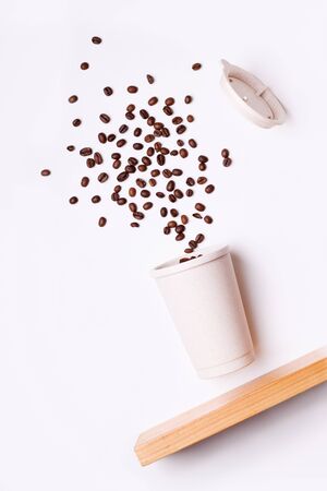reusable coffee cup in flight with coffee beans on a white background.の写真素材