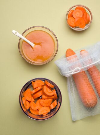 cooking homemade baby food from carrots on a green backgroundの写真素材