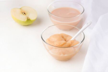 two glass bowls with homemade baby puree on a white background. copy spaceの写真素材