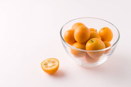 tropical kumquat fruit in a glass bowl on a white background. copy spaceの写真素材