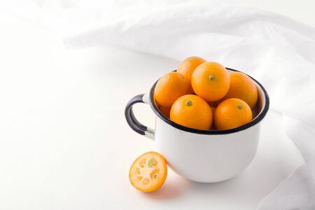 tropical citrus fruit kumquat in a mug on a white background. copy spaceの写真素材