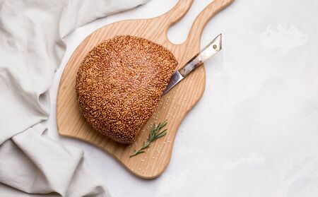 sliced loaf of white bread with sesame seeds on a wooden board. copy spaceの写真素材