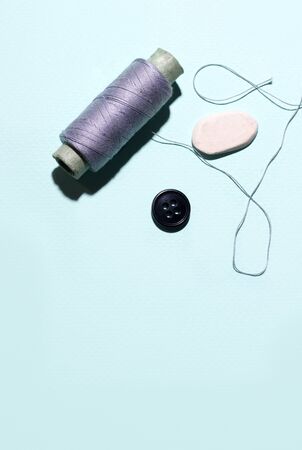 Sewing home concept. Threads on a blue background. Vertical photo copy spaceの写真素材
