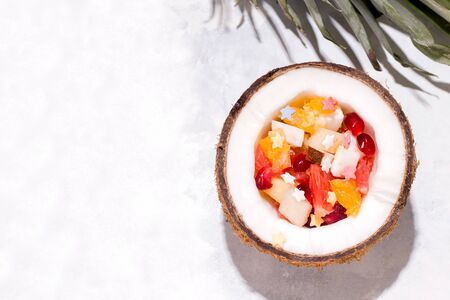 Summer food, fruits in coconut on a concrete background. Copy spaceの写真素材
