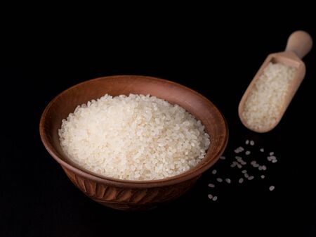 rice in a clay bowl on a black backgroundの写真素材