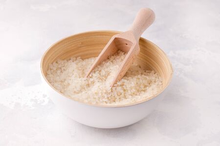 Rice in a bowl with a scoop on a white background.の写真素材