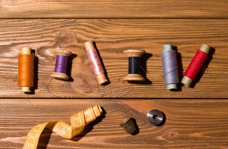 threads of different colors on a wooden table. view from aboveの写真素材
