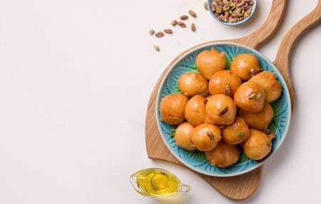 arabic sweet dessert from lokma lean products in a plate on a white background. copy spaceの写真素材