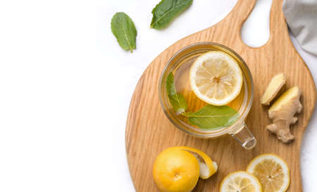 Cup of tea with lemon, mint and ginger close-up on a white background. Copy spaceの写真素材