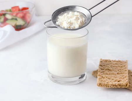 Fermented drink kefir in a glass with granules of bacteria on a white backgroundの写真素材