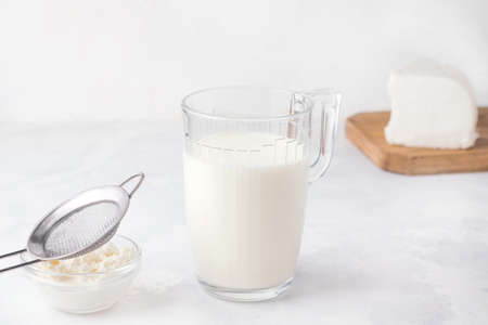 Fermented kefir drink in a glass and bacteria granules in a plate on a white background. Milk products.の写真素材