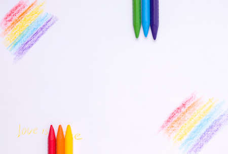 The concept of children's creativity drawing. Crayons on a painted sheet of white paper. Copy space
