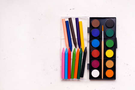 The concept of children's creativity, drawing. Paints and crayons of different colors on a white background. Copy spaceの写真素材