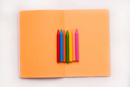 The concept of the school year and drawing. Crayons of different colors on a notebookの写真素材